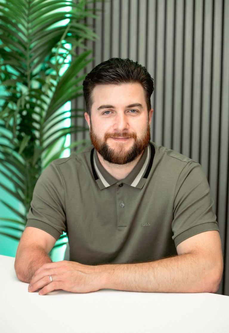 Ricky Crump seated portrait in an olive green polo shirt