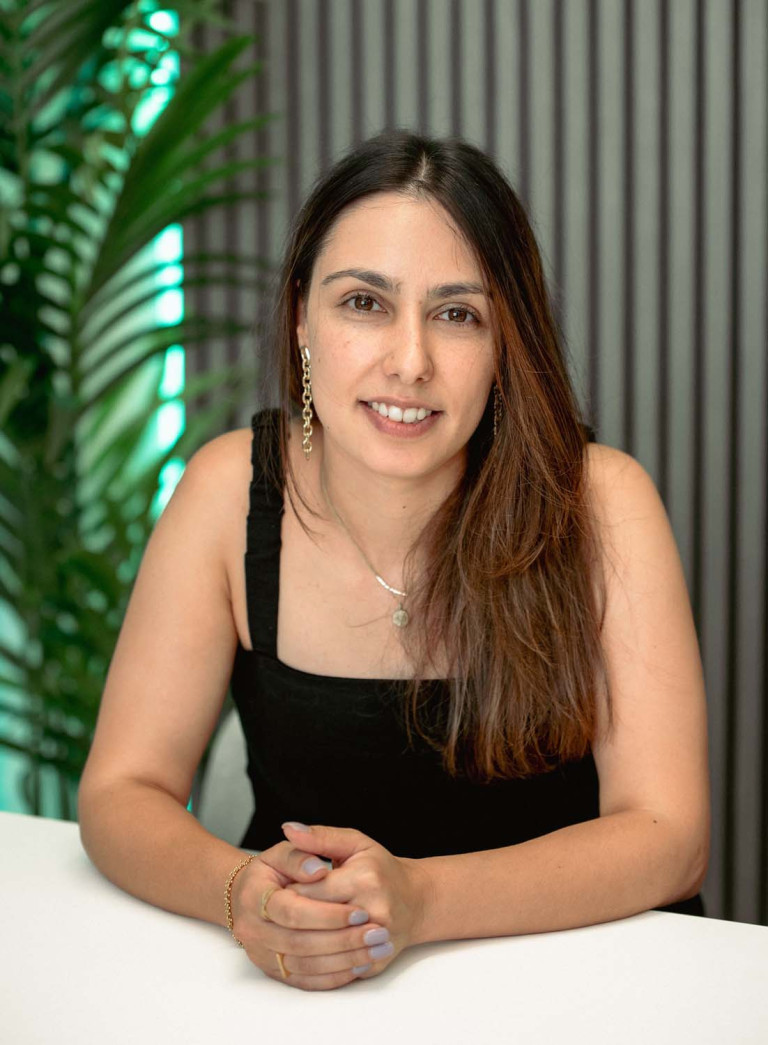 Angela Ferreira seated portrait with hands clasped at a table