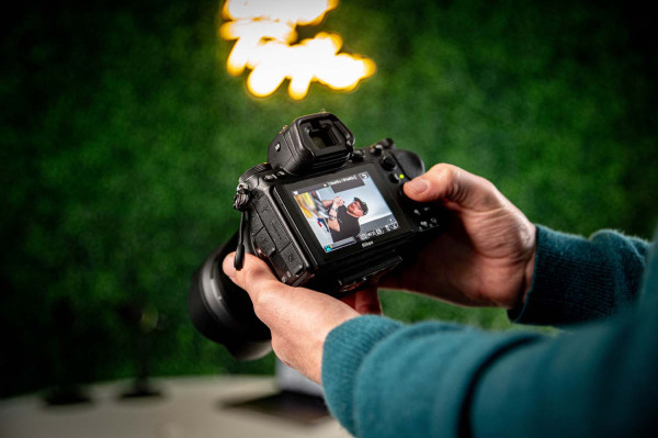 Hands holding camera reviewing portrait photo on camera screen