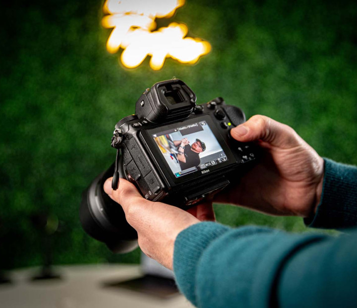 Hands holding camera reviewing portrait photo on camera screen